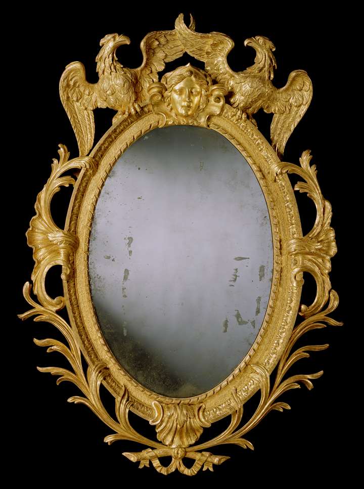 A GEORGE II CARVED GILTWOOD OVAL MIRROR